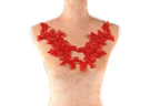 A mannequin torso wearing a red lace necklace with a floral pattern.