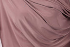 a close-up view of a soft, flowing fabric in a deep pink color. The fabric appears to be made of silk or a similar material, with a smooth and shiny texture. The fabric is draped or folded in a way that creates a sense of movement and softness.