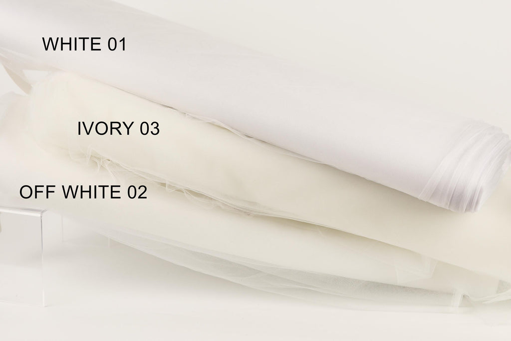 three different shades of white fabric, each labeled with a number. The first fabric is labeled "WHITE 01", the second fabric is labeled "IVORY 03", and the third fabric is labeled "OFF WHITE 02".