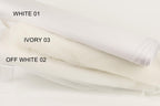 three different shades of white fabric, each labeled with a number. The first fabric is labeled "WHITE 01", the second fabric is labeled "IVORY 03", and the third fabric is labeled "OFF WHITE 02".