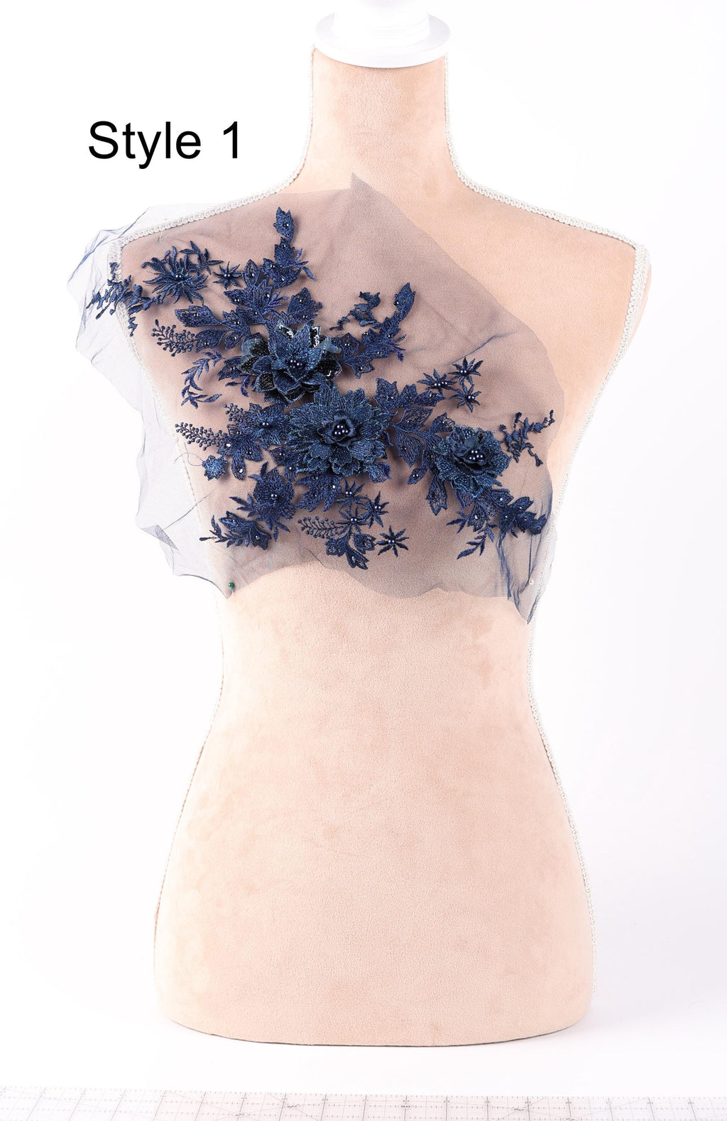 A mannequin with a decorative fabric piece on its chest, featuring a floral pattern in shades of blue.