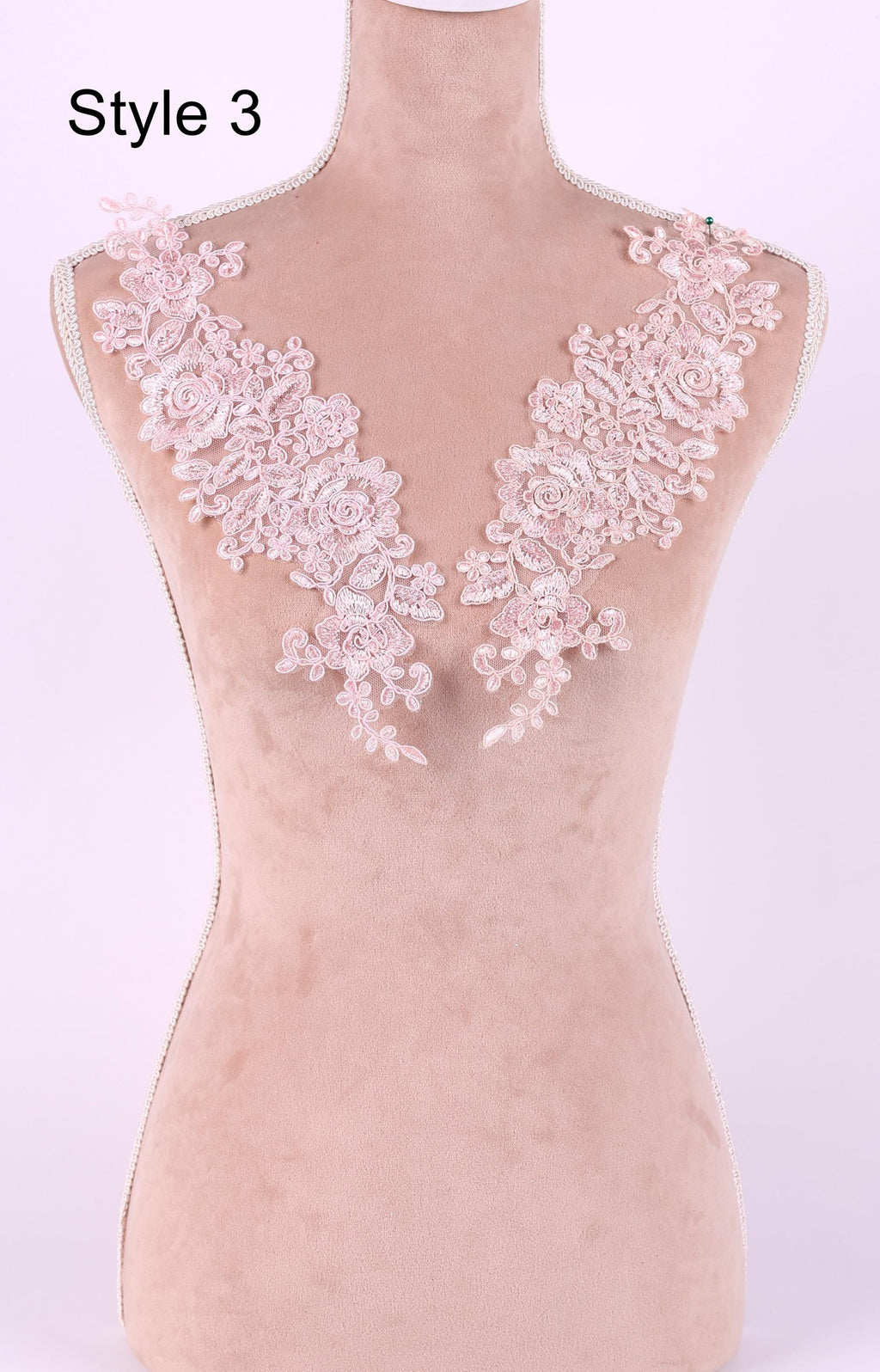 A mannequin with a pink floral lace overlay on its bust area, displayed against a light pink background.