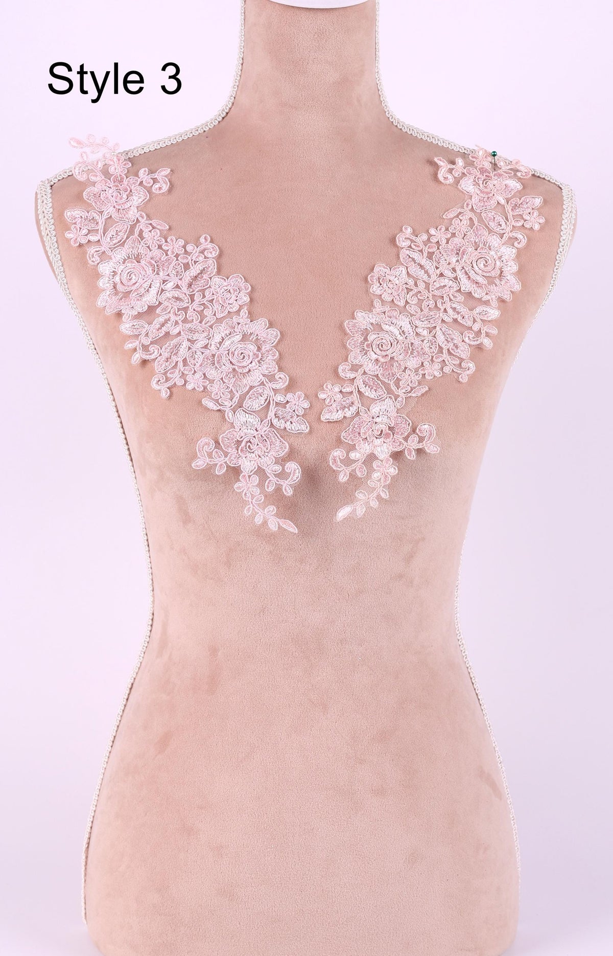 A mannequin with a pink floral lace overlay on its bust area, displayed against a light pink background.