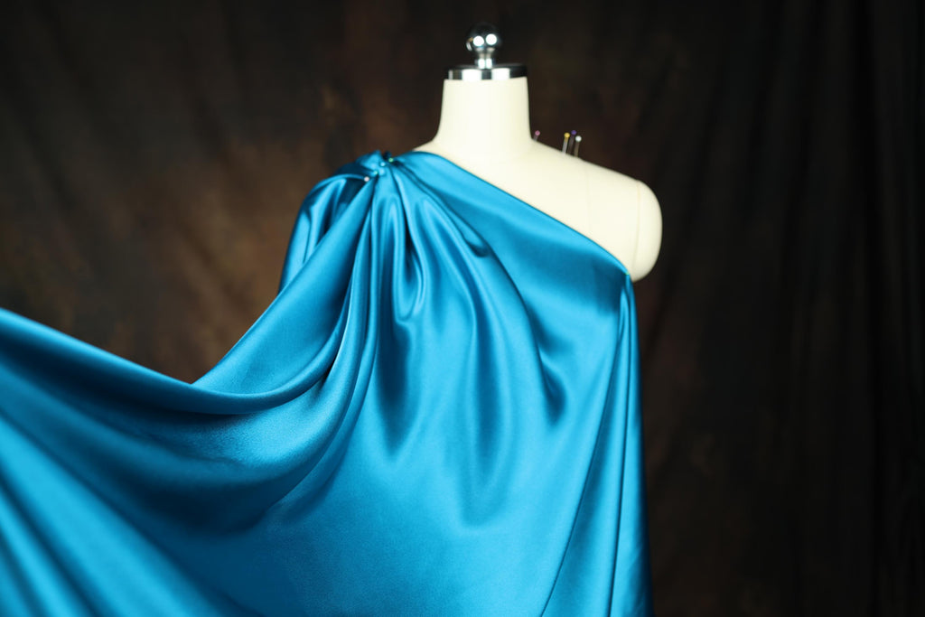 a mannequin wearing a blue draped dress