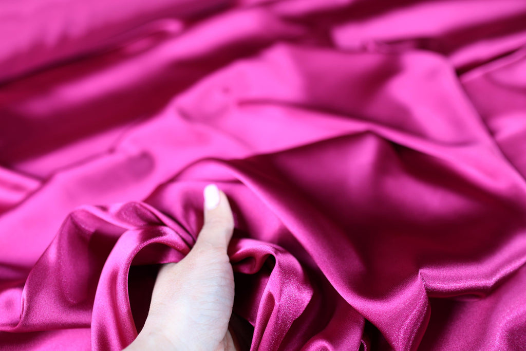 a person&#39;s hand on a pink cloth