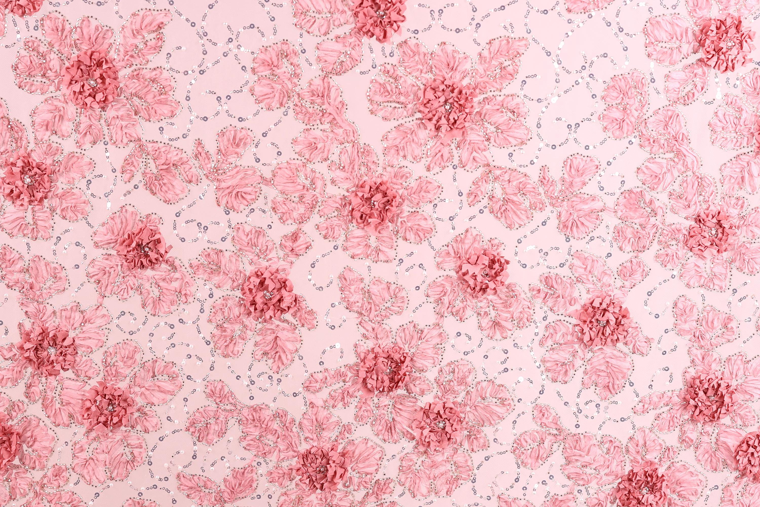 a repeating pattern of pink flowers with green leaves on a light pink background.