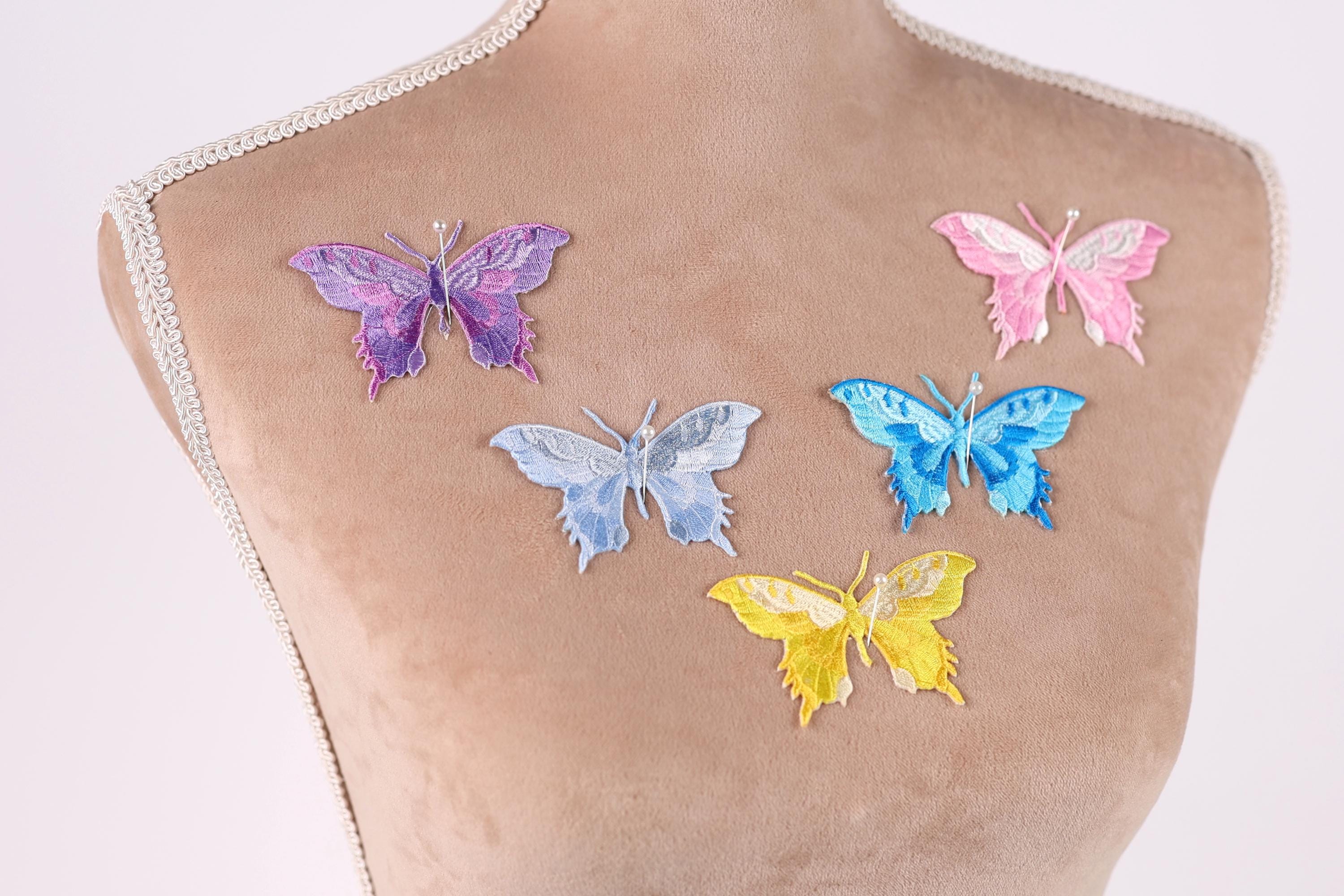 a mannequin with six colorful butterfly patches on its chest.