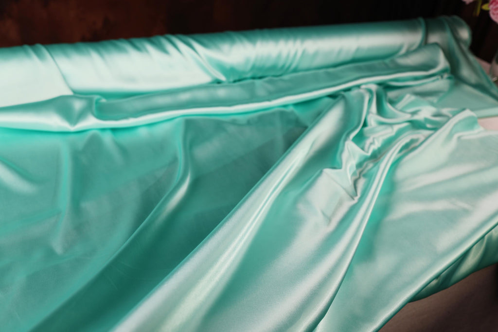 a close up of a bed with a green sheet