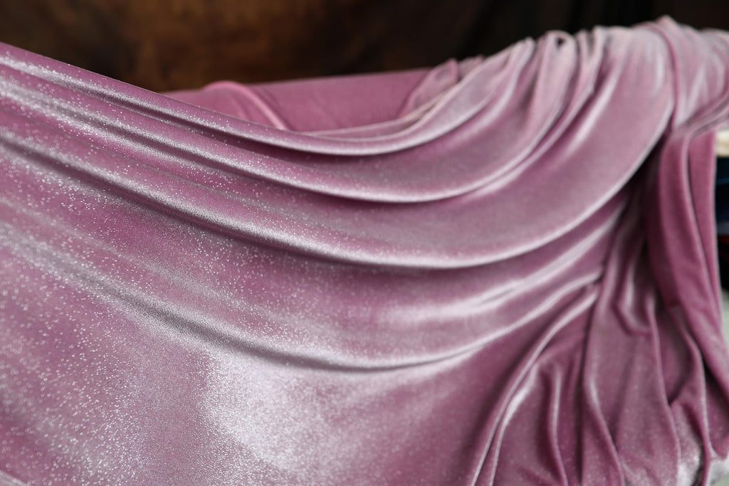 a close up of a purple cloth on a bed