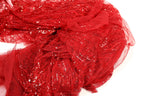 a close-up view of a red sequined fabric, with a textured and shiny appearance.