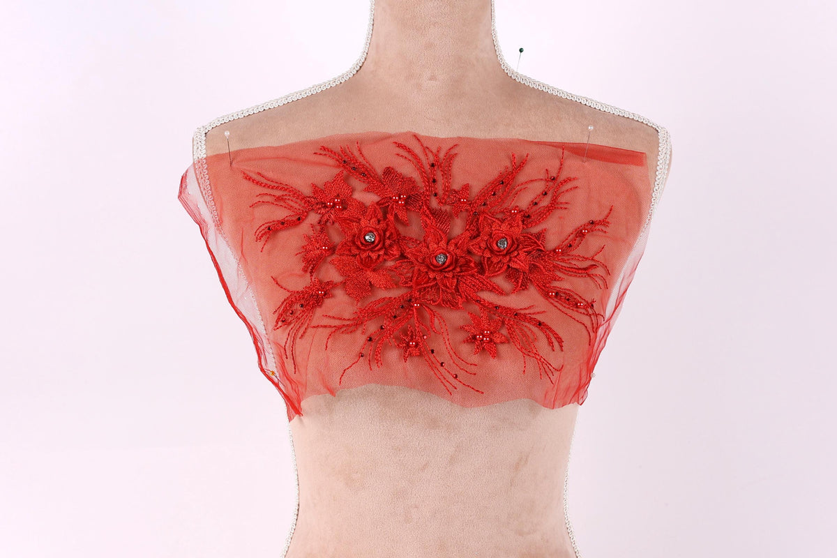 A mannequin wearing a red, sheer fabric with a floral design.