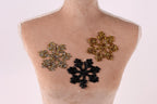 A mannequin torso with three decorative snowflake-shaped embellishments on it, each with a different color and design.
