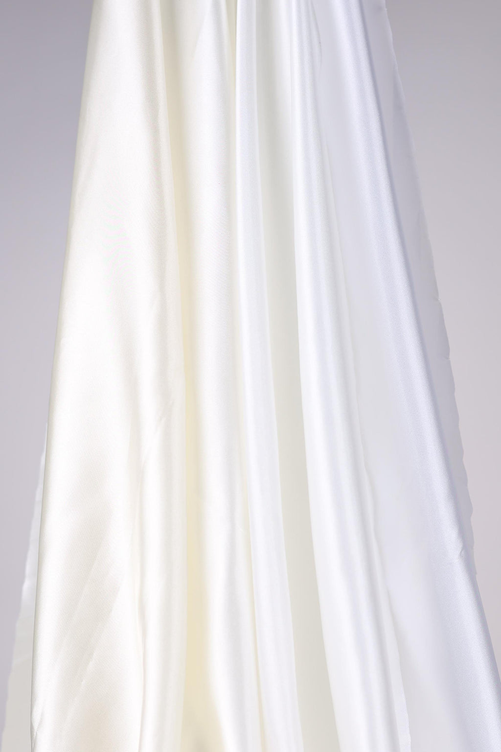The image is a close-up of a white fabric, possibly silk or satin, with a smooth and flowing texture.