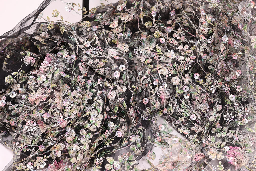 The image is a close-up view of a fabric with a floral pattern, featuring a variety of colorful flowers and leaves.