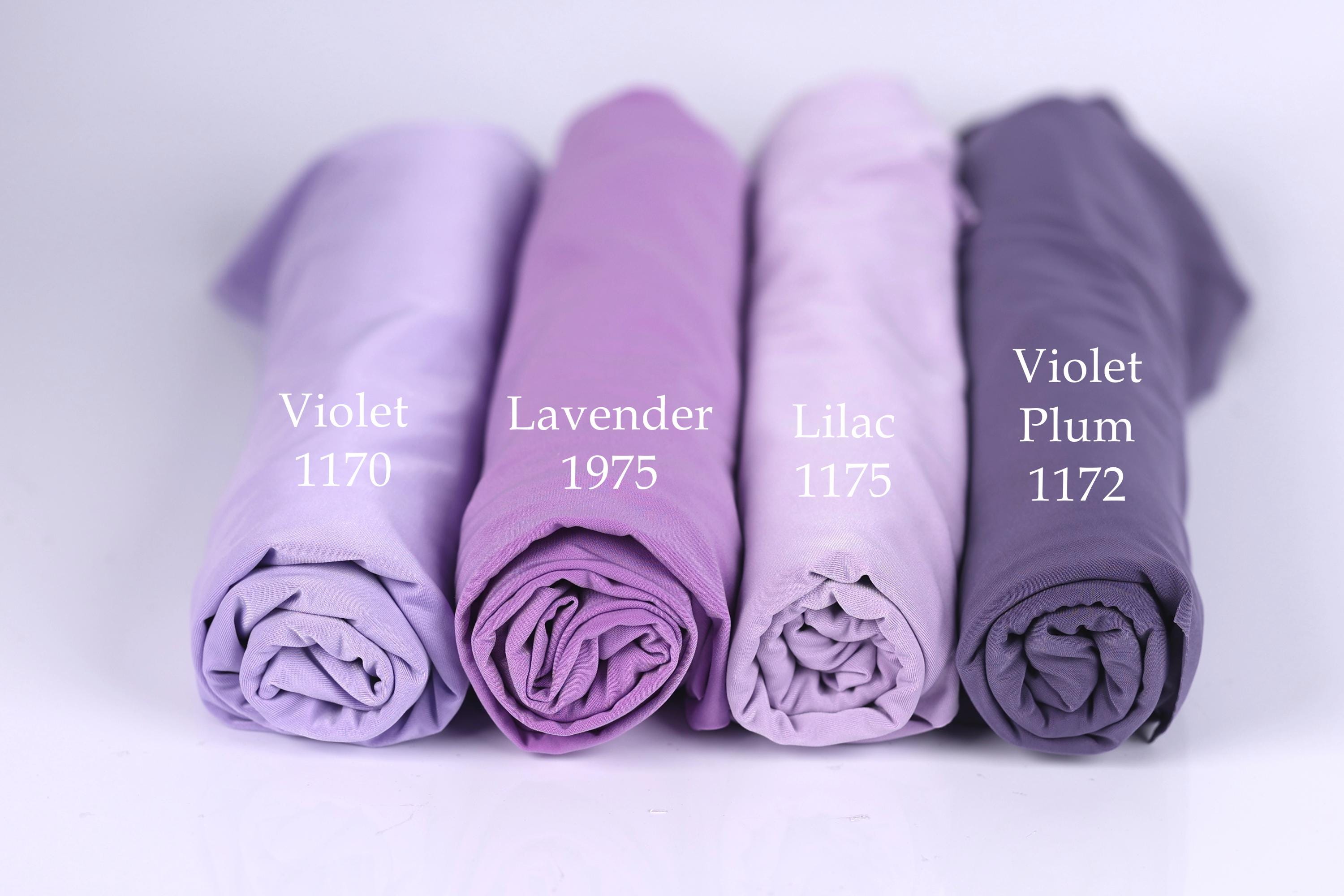 Four rolled-up fabric swatches in different shades of purple, labeled with the names of the colors: Violet, Lavender, Lilac, and Plum.