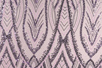 a repeating pattern of purple and black sequin designs on a light pink background.