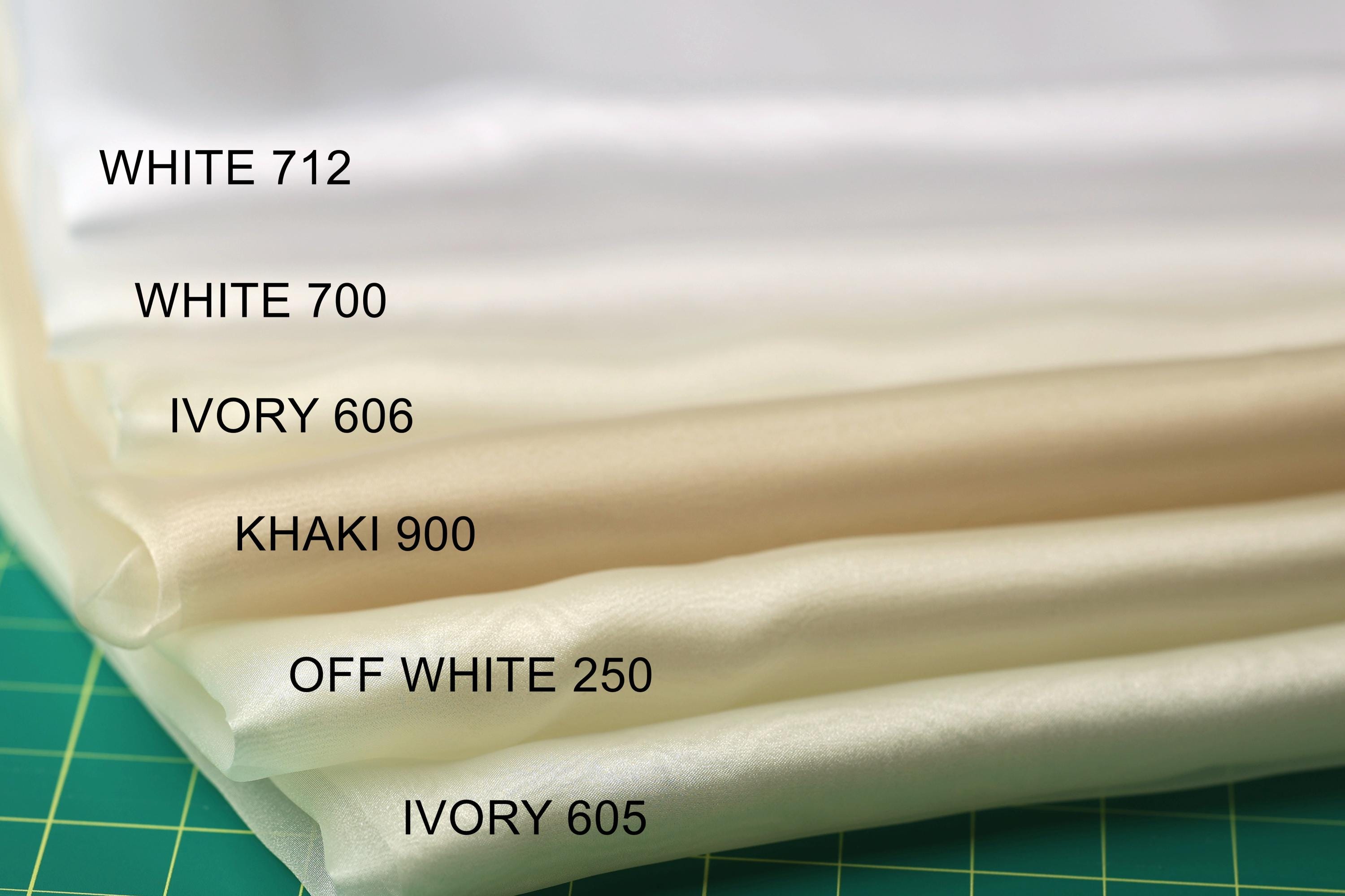 A close-up image of a stack of fabric swatches, each with a different color, arranged on a green surface.