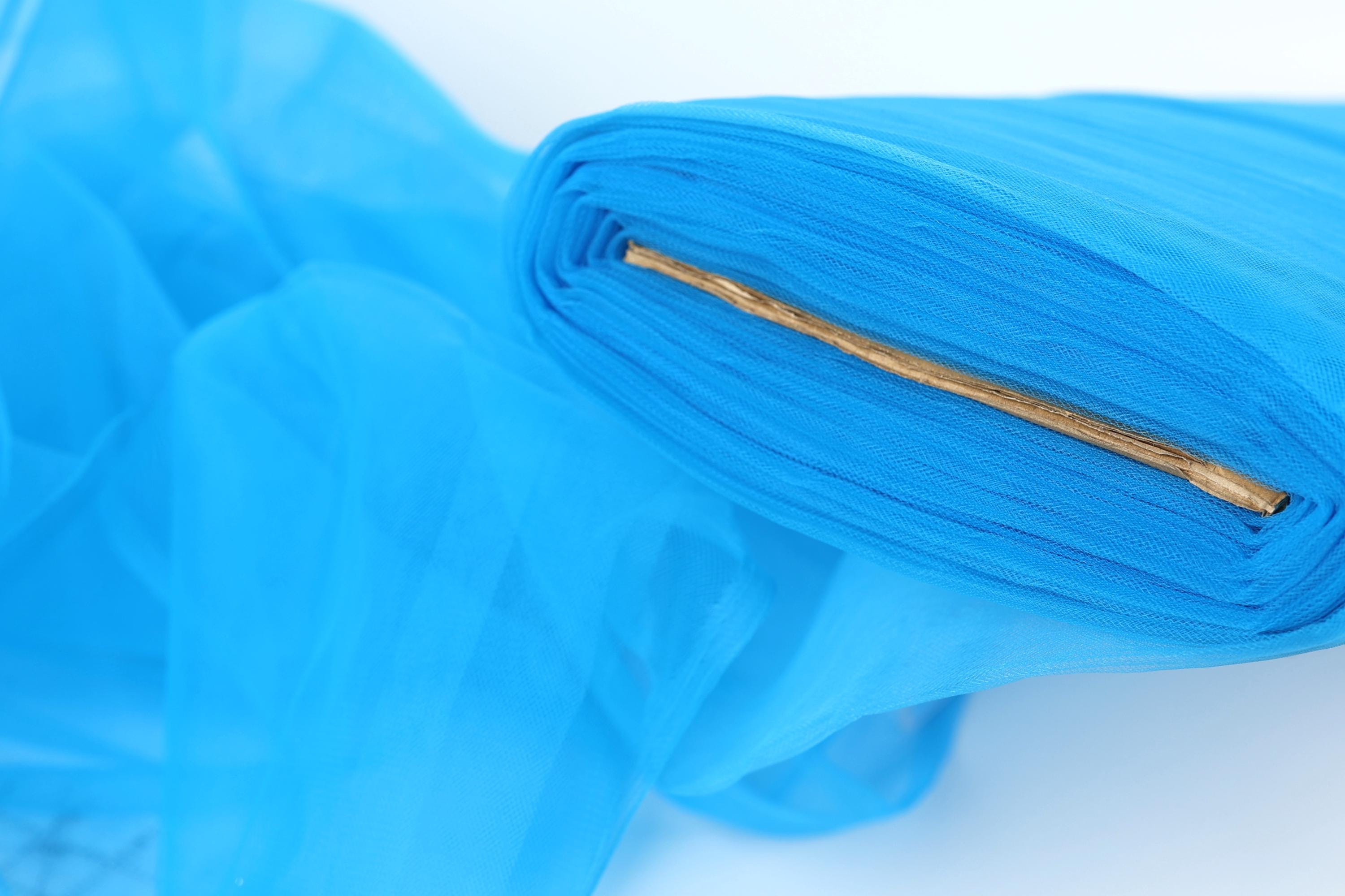 A close-up view of a blue fabric with a gold zipper, creating a visually striking contrast.