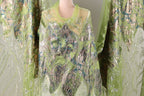 a mannequin wearing a green and silver sequined dress with a sheer overlay.