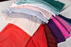 a pile of clothes sitting on top of a bed