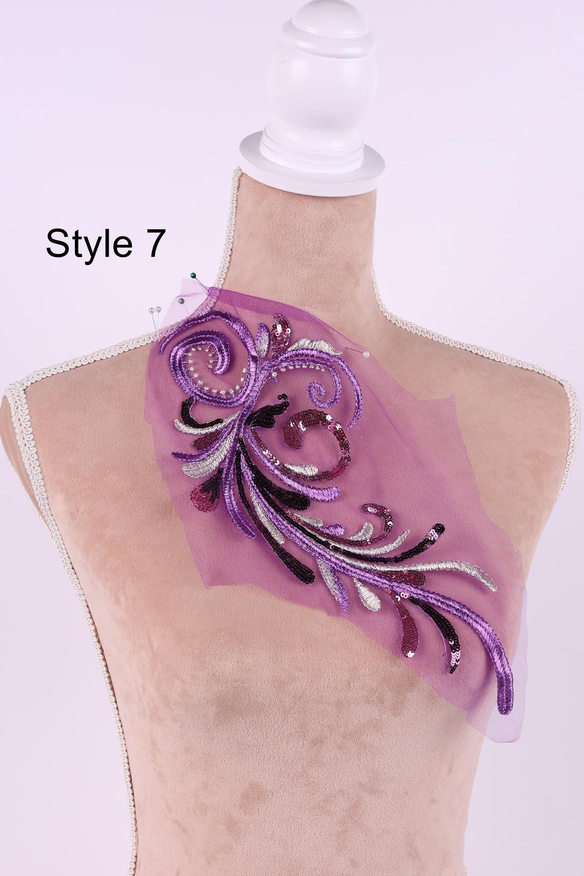 A mannequin with a decorative purple and white floral embroidered on its bust, displayed against a white background.