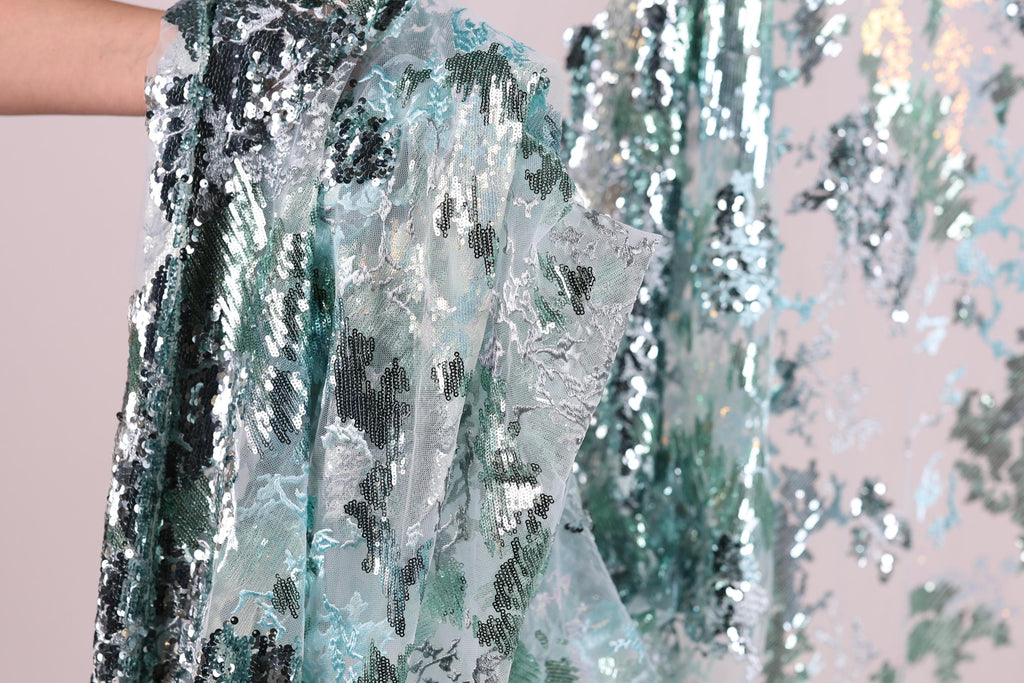 a close-up view of a sequin fabric with a floral pattern.