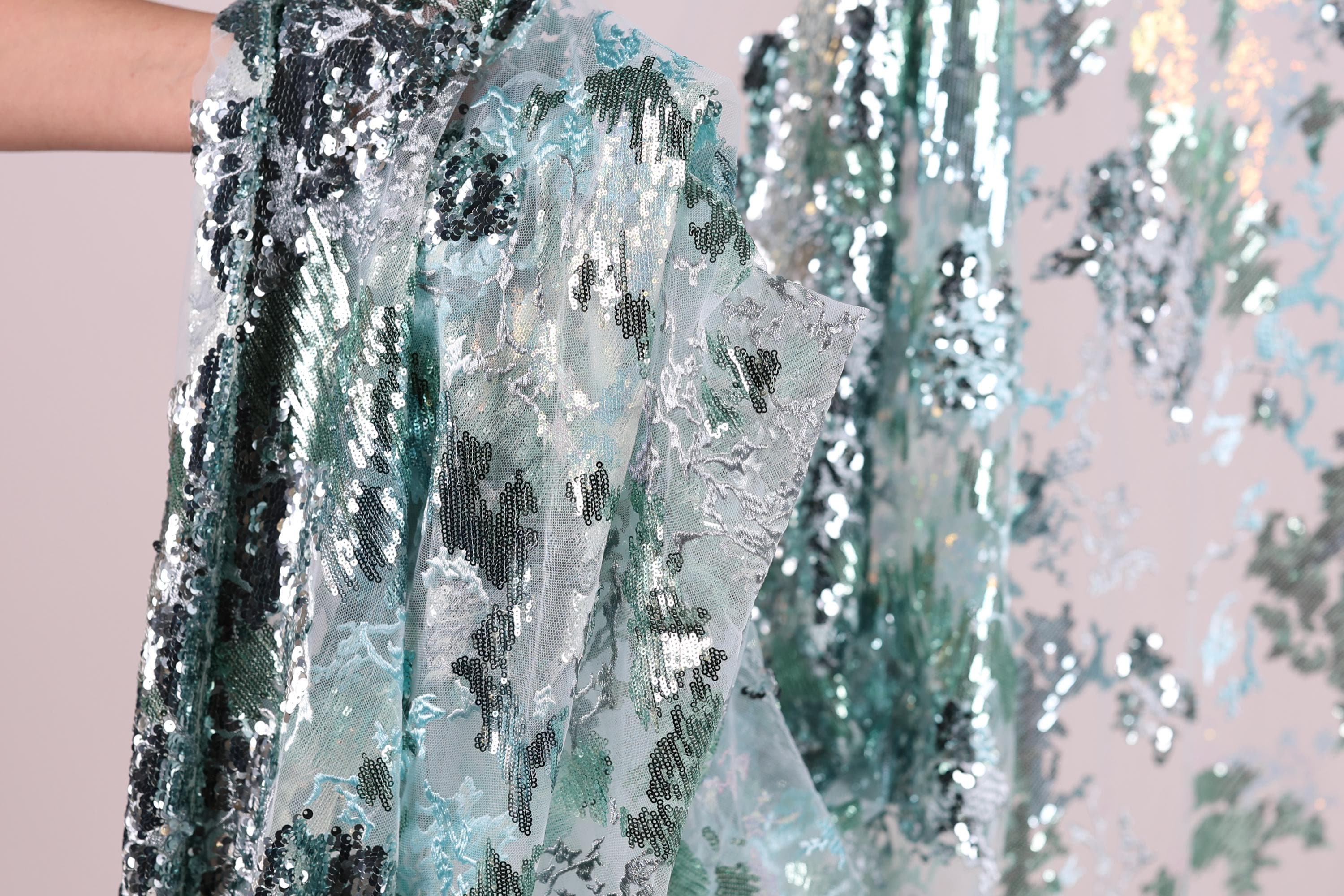 a close-up view of a sequin fabric with a floral pattern.