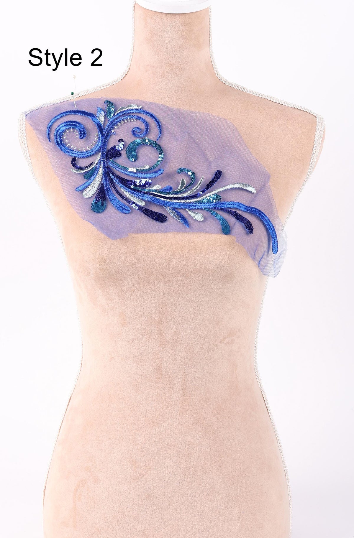 A mannequin with a decorative fabric patch on its shoulder.