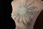 the back of a woman's dress with a flower on it