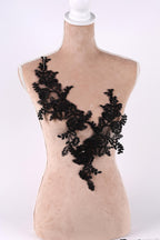 A mannequin torso with a black lace overlay, featuring a floral pattern.