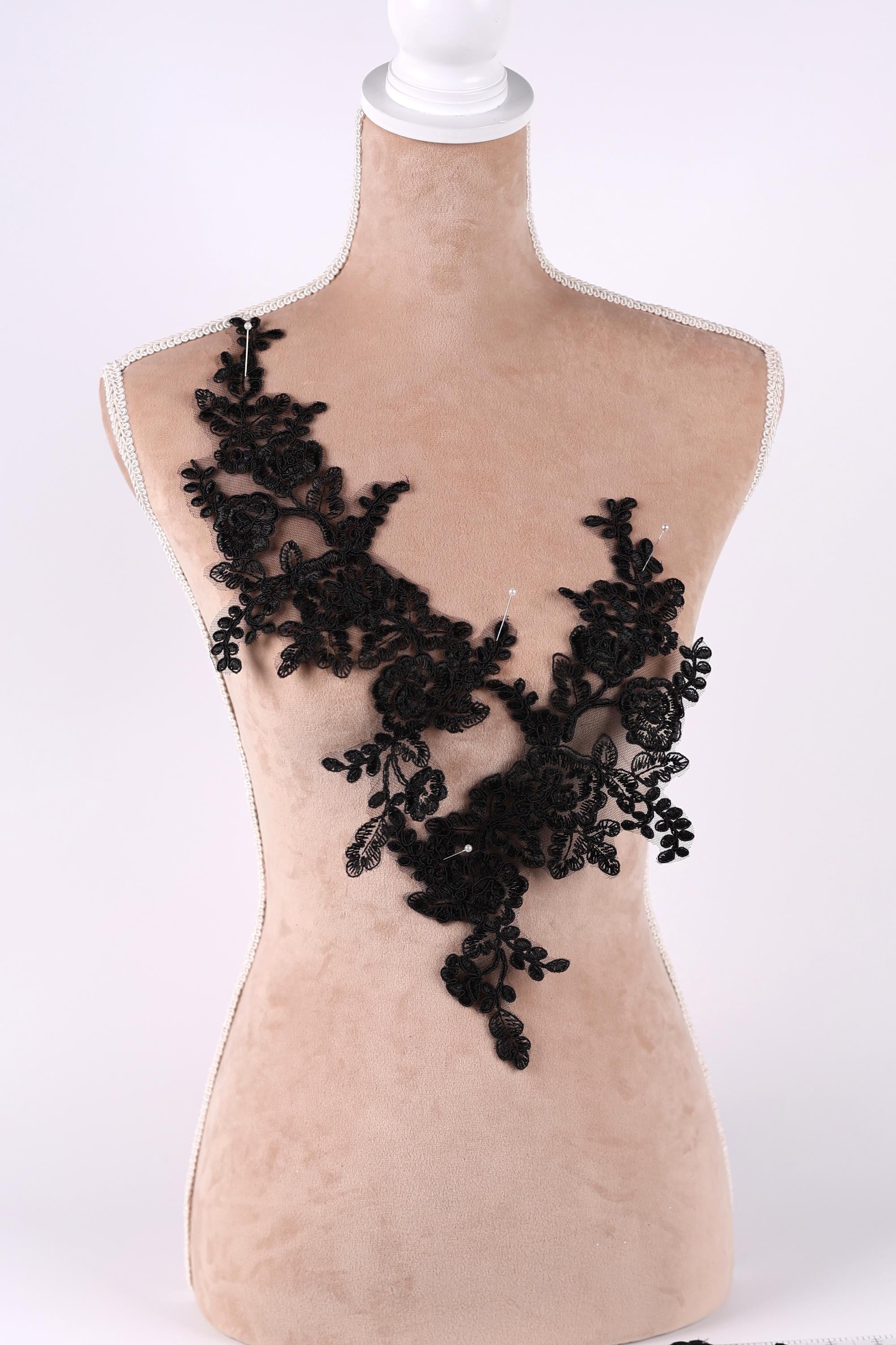 A mannequin torso with a black lace overlay, featuring a floral pattern.