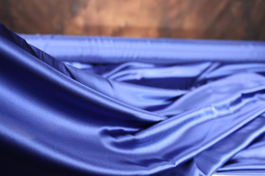 a close up of a blue cloth with a wooden background