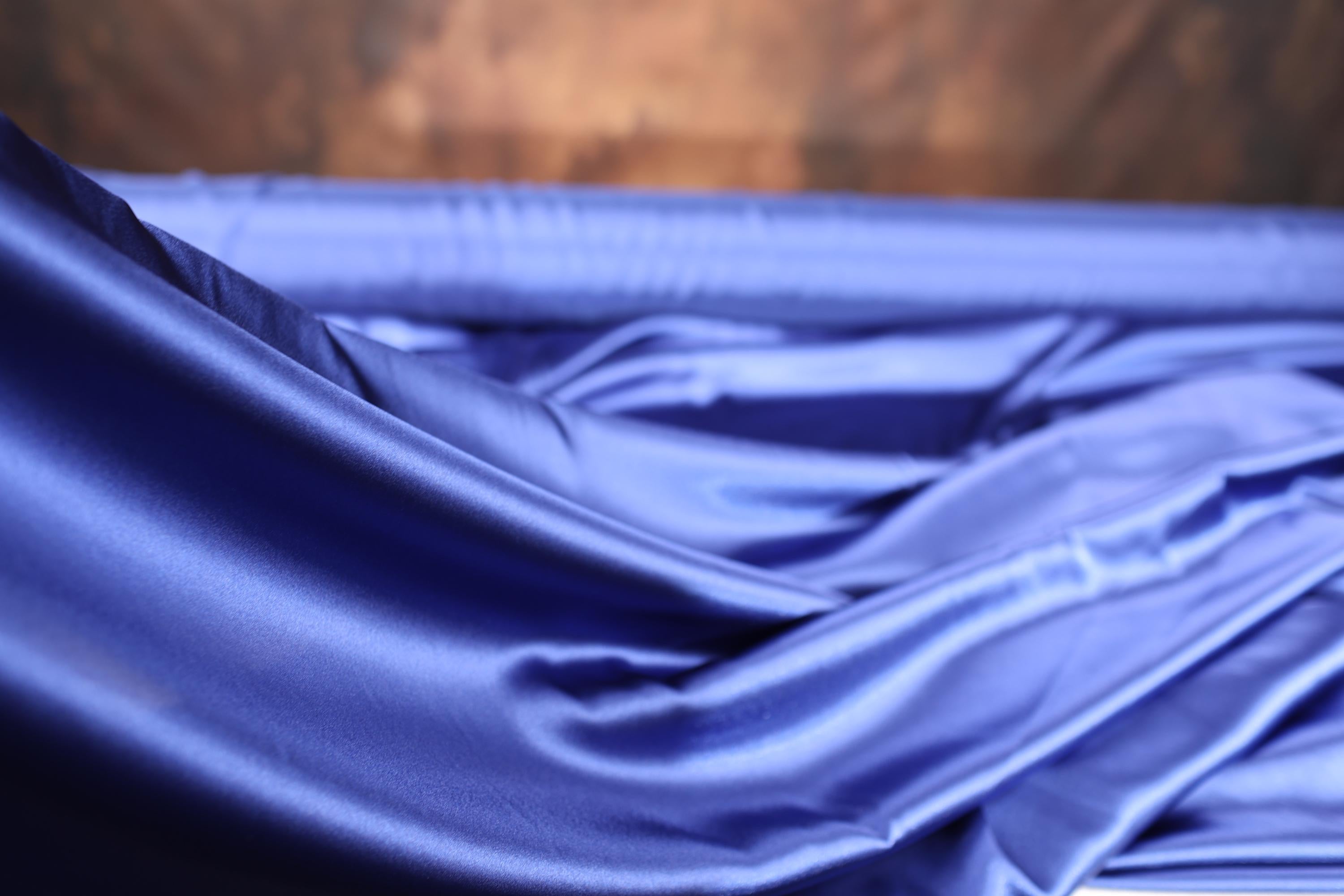 a close up of a blue cloth with a wooden background
