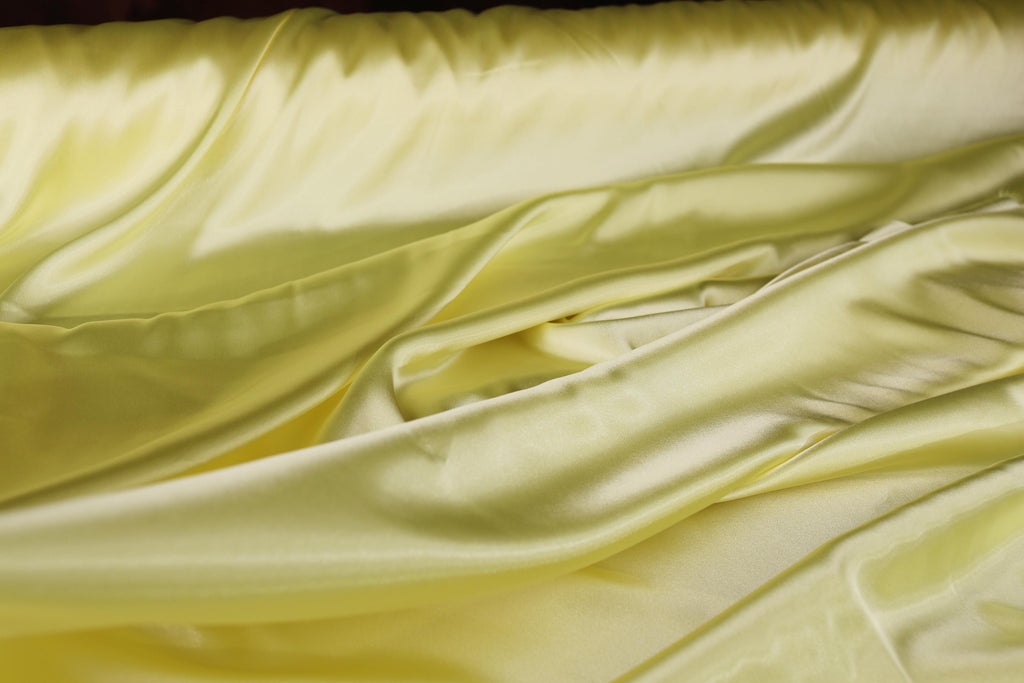 a close up of a bed with a yellow comforter