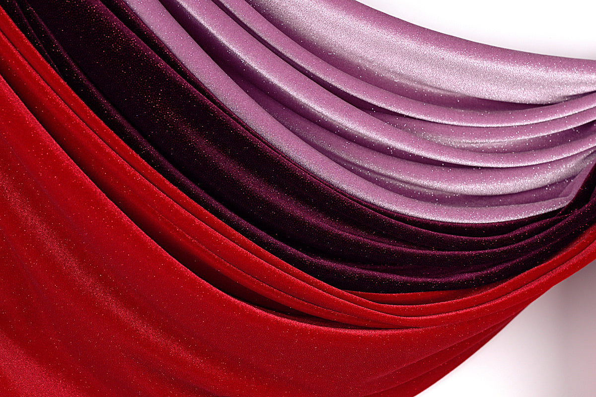 a close-up view of a fabric with a gradient of red and purple colors, creating a visually striking and vibrant pattern.