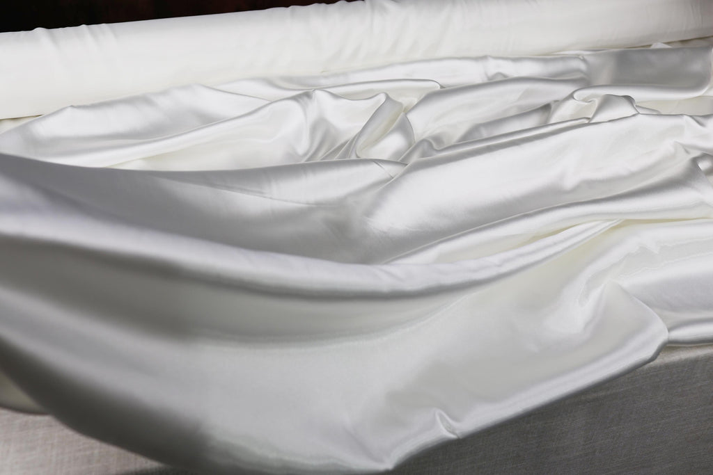 an unmade bed with white sheets and a pillow
