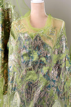 a mannequin wearing a green and silver sequined dress with a floral pattern.