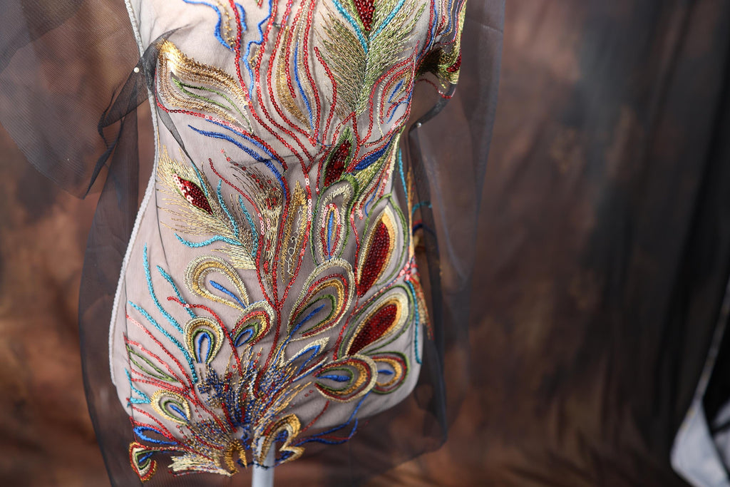 a close-up view of a decorative dress with intricate embroidery and a floral pattern.