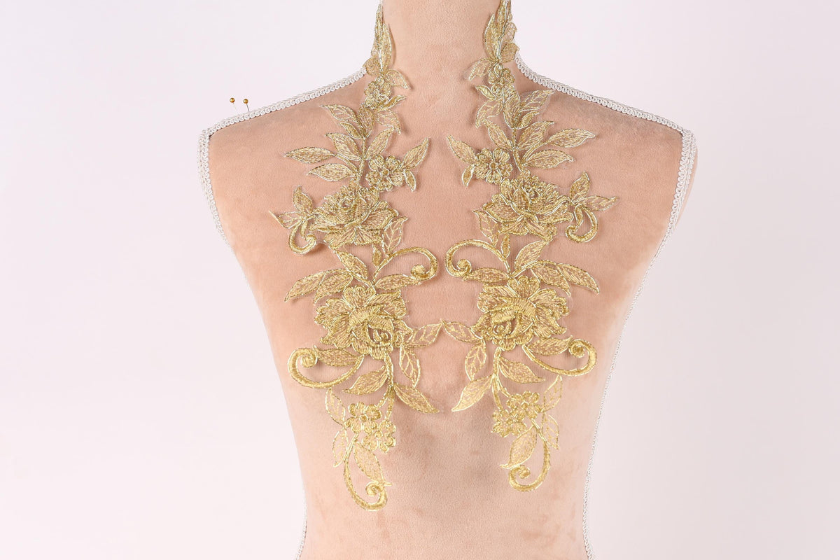 a mannequin torso with intricate gold embroidered floral designs on the back.