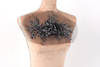 a mannequin torso with a decorative floral embroidery on the bust area.