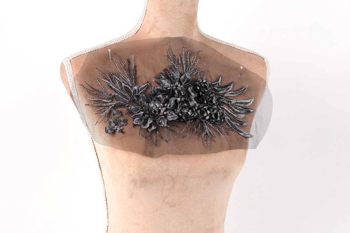 a mannequin torso with a decorative floral embroidery on the bust area.