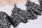 a close-up view of a black lace fabric with intricate, decorative patterns.