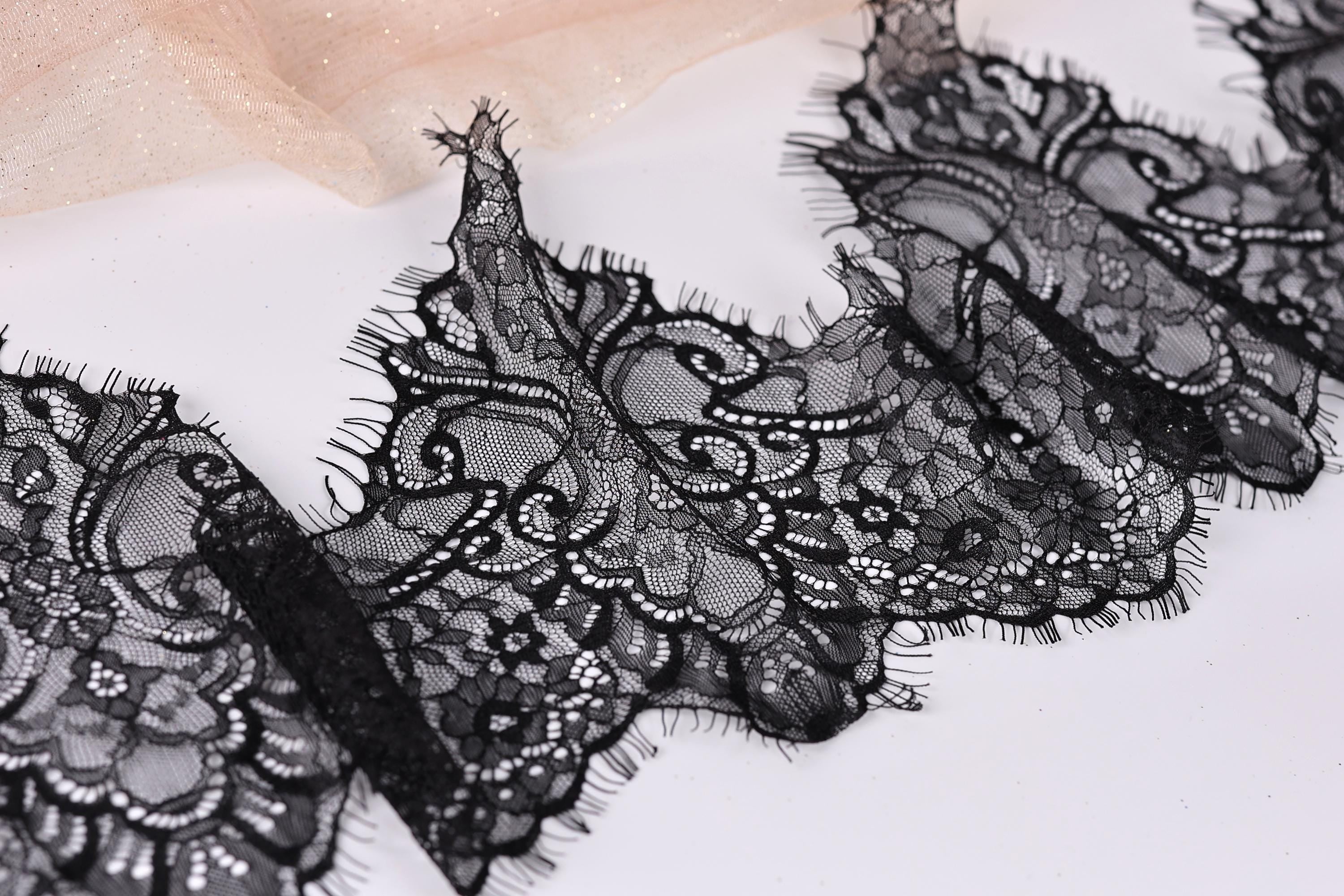 a close-up view of a black lace fabric with intricate, decorative patterns.