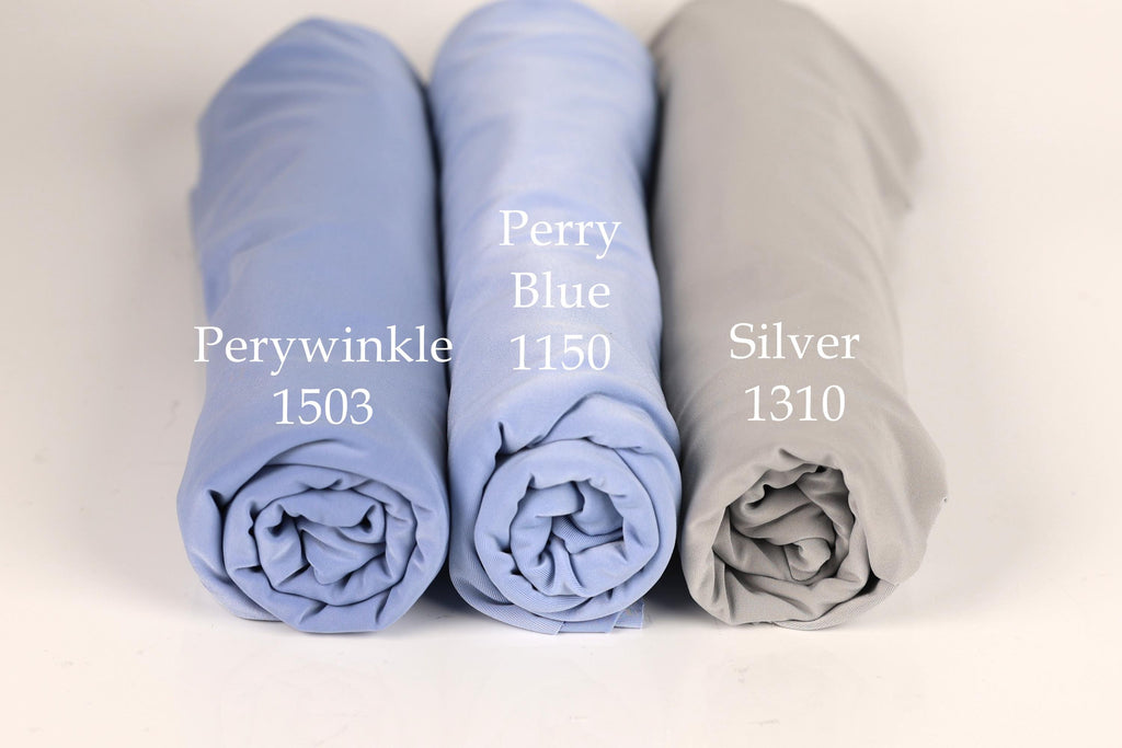 Three rolled-up fabric swatches in different colors - blue, light blue, and gray - are displayed side by side.