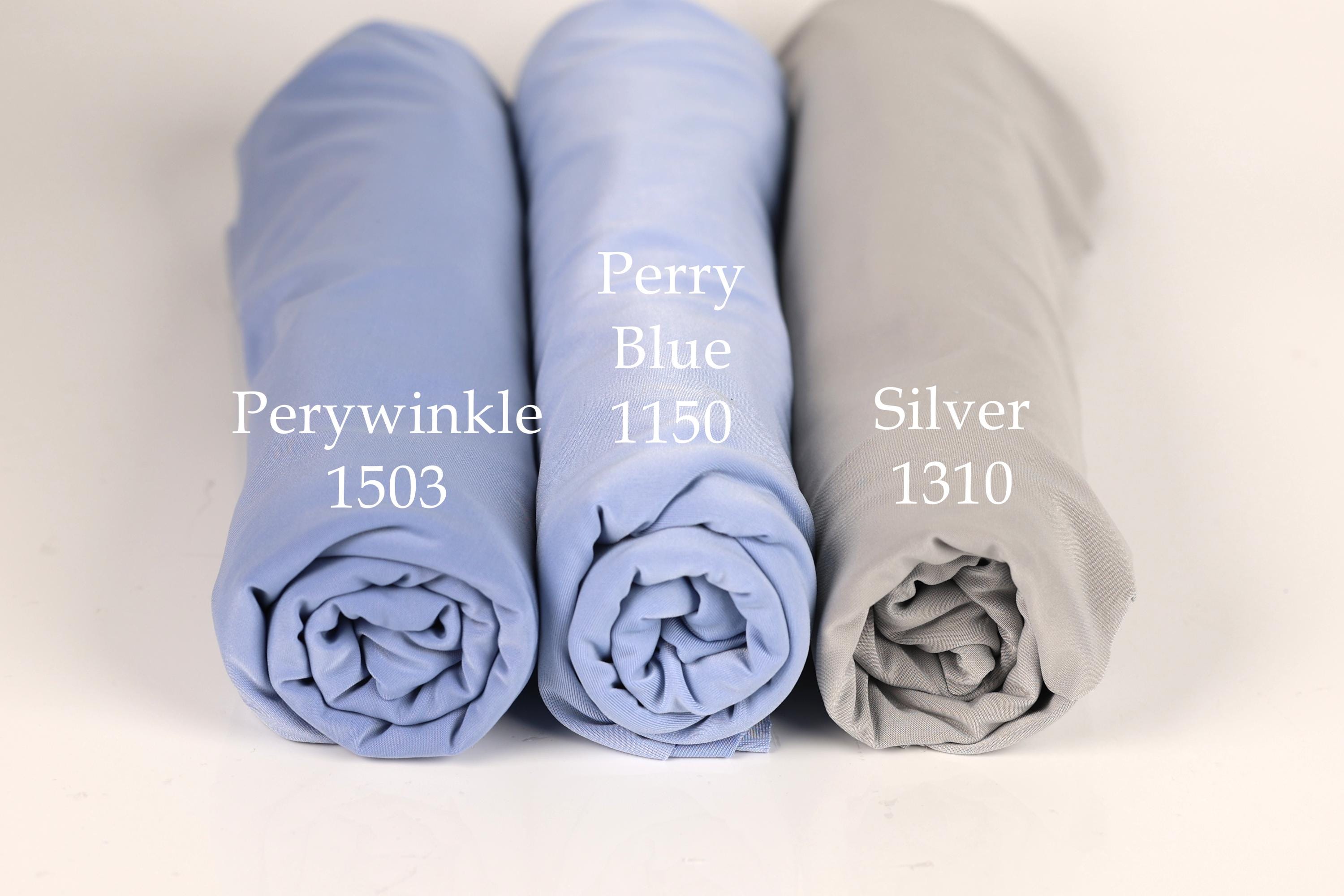 Three rolled-up fabric swatches in different colors - blue, light blue, and gray - are displayed side by side.