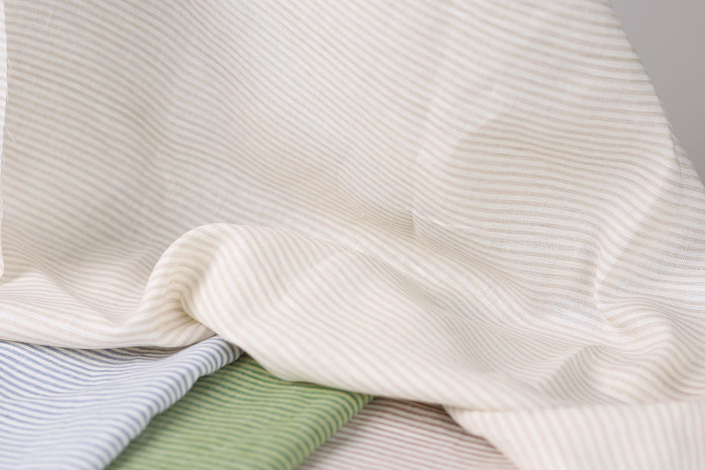 a close-up view of a fabric with horizontal stripes in various colors, including white, blue, and green.