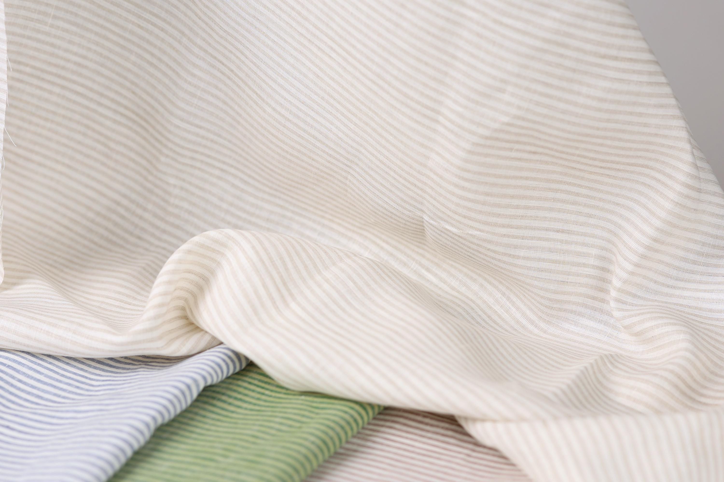 a close-up view of a fabric with horizontal stripes in various colors, including white, blue, and green.
