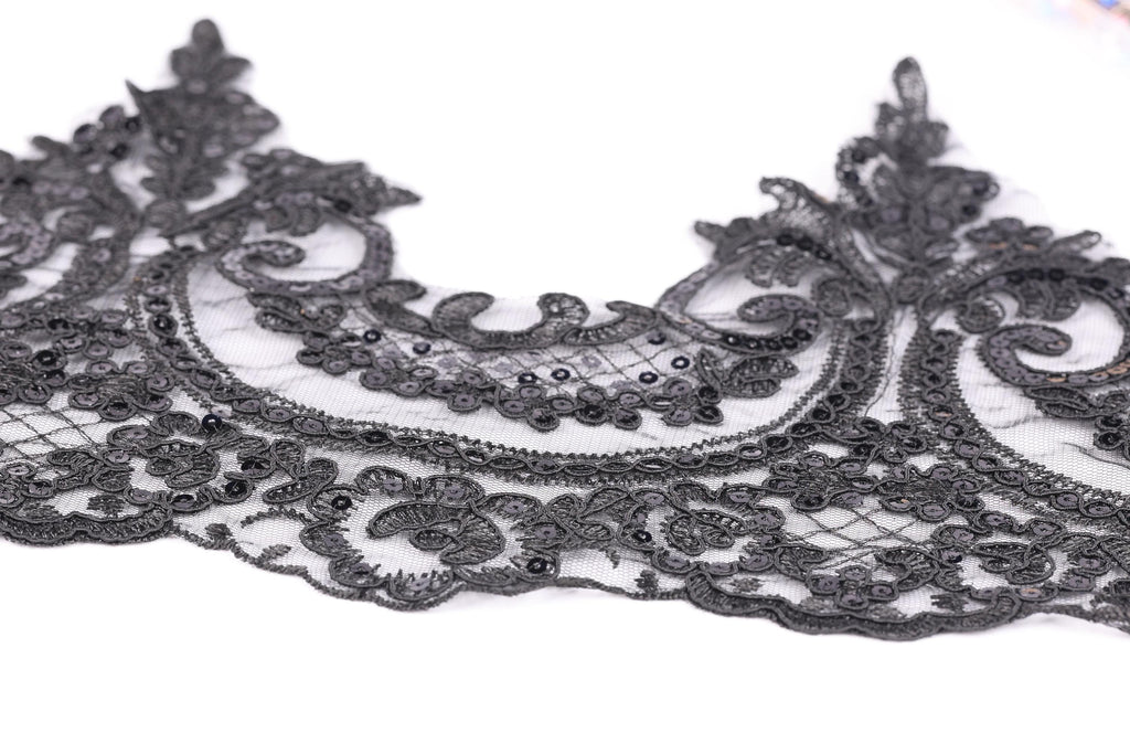 a close-up view of a delicate, intricate black lace piece with a floral pattern.