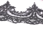 a close-up view of a delicate, intricate black lace piece with a floral pattern.