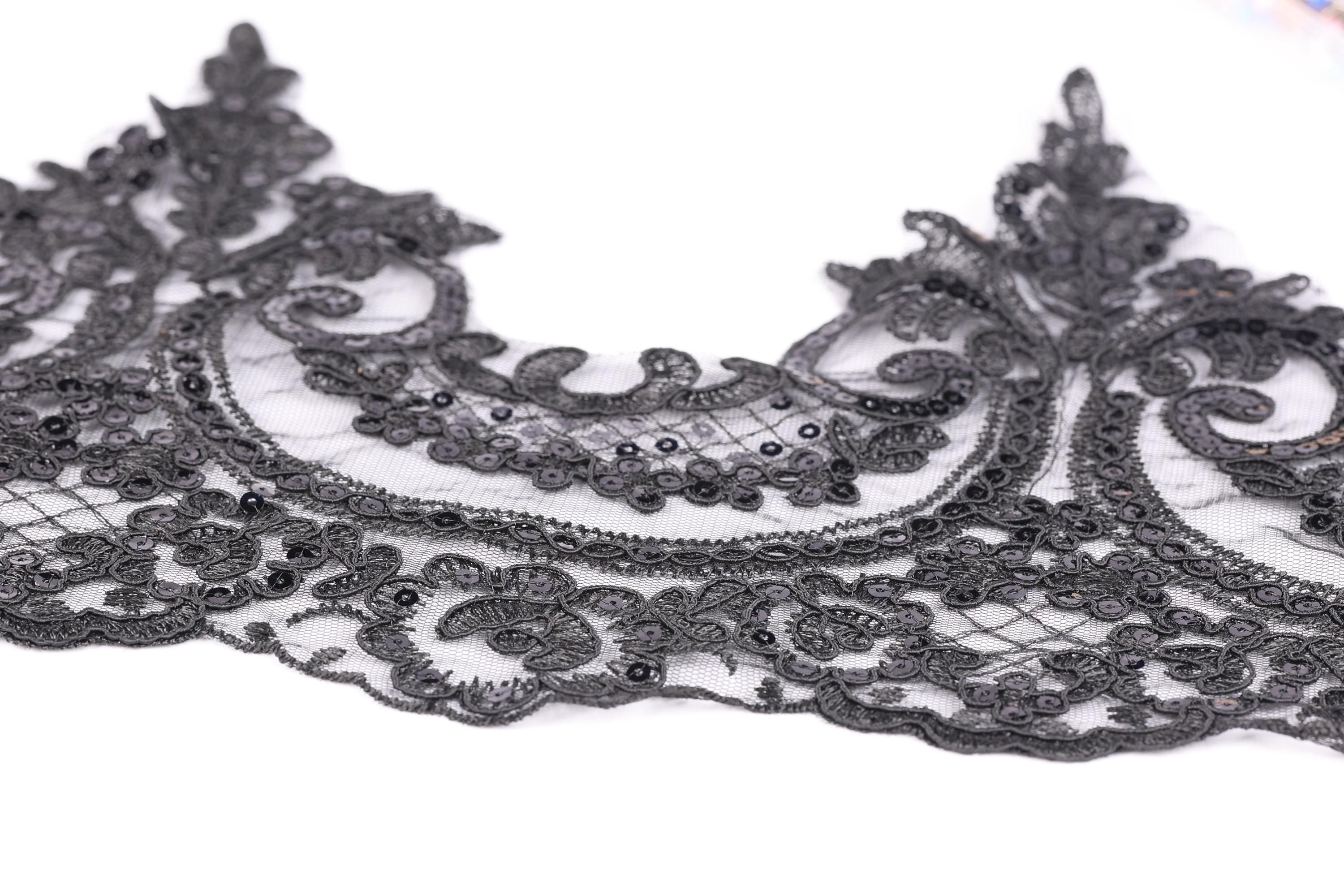 a close-up view of a delicate, intricate black lace piece with a floral pattern.